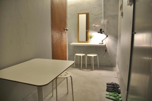 怡保GRAYHAUS INN Ipoh的配有桌子、凳子和镜子的房间