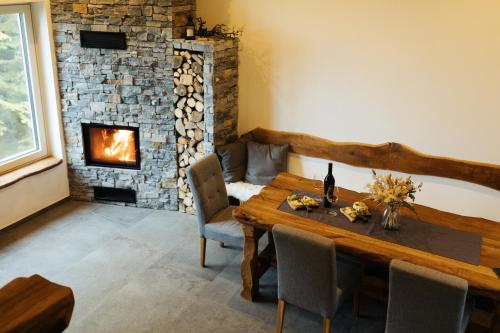 耶塞尼采Alpine Cottage Golica的一间带桌子和壁炉的用餐室