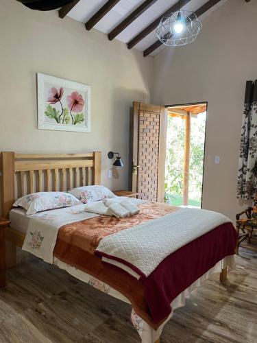 库尼亚Pousada Recanto dos Pássaros的一间卧室设有一张大床和一个窗户。