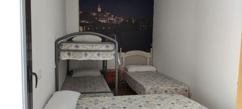 托马雷斯APART-DUPLEX-ATICO Tomares的小房间设有两张床和镜子