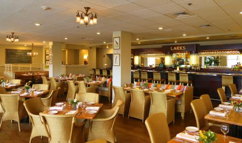 阿什兰阿什兰温泉酒店 的一间带桌椅的餐厅和一间酒吧