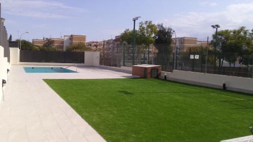托马雷斯APART-DUPLEX-ATICO Tomares的绿草庭院和游泳池