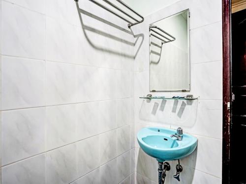 巨港SUPER OYO 91805 Hotel Wisma Bari的浴室设有蓝色水槽和镜子