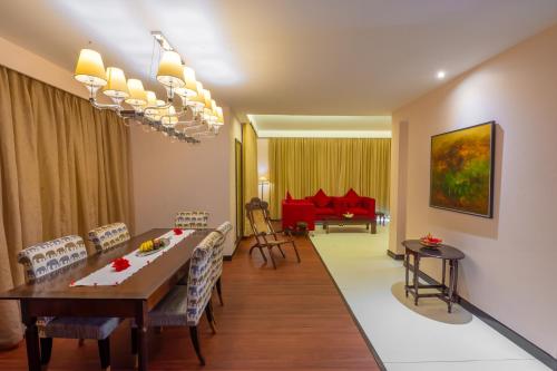坎多林O Hotel Goa, Candolim Beach的用餐室以及带桌椅的起居室。