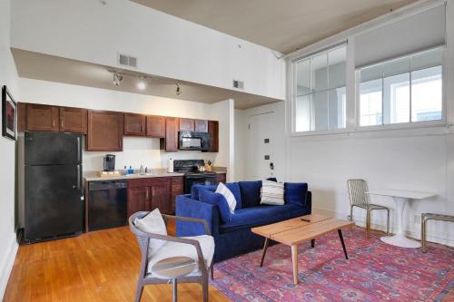 路易斯威尔Apartment With King Bed In Downtown Louisville的一间带蓝色沙发的客厅和一间厨房