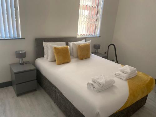 诺丁汉Nottingham City Centre Short Stay Apartments with Parking的一间卧室配有一张大床和毛巾