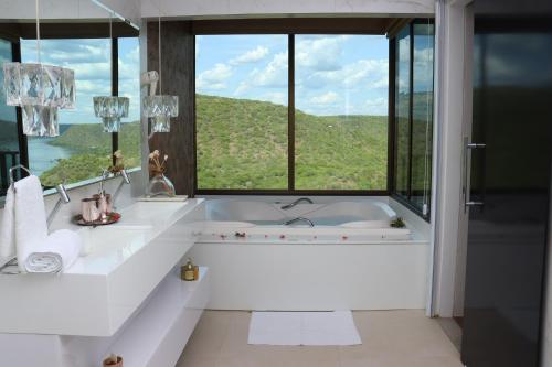 皮拉尼亚斯Pedra do Sino Hotel的一间带大窗户和浴缸的浴室