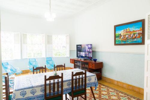 卡塔赫纳Casa Colonial en Manga的一间带桌子和电视的用餐室