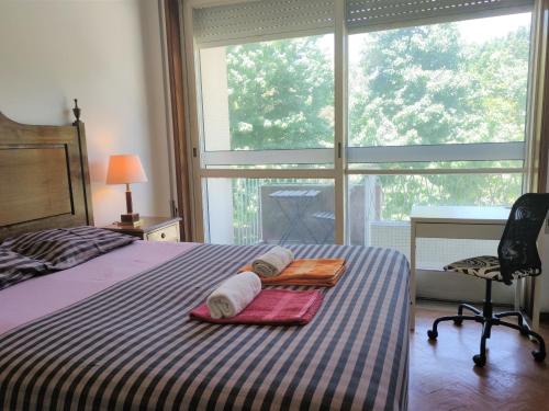 波尔图DISCOVER PORTO - Boavista的一间卧室配有带2条毛巾和椅子的床