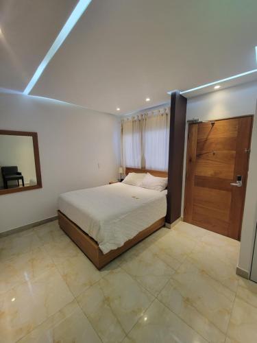 圣多明各Marcel Suites的一间卧室配有一张床和一扇木门