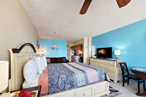 代托纳海滩Pirates Cove Condo Unit #209的一间卧室配有一张床和一张书桌及电视