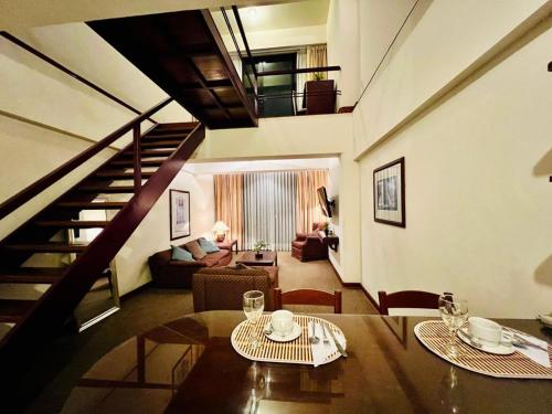 利马Miraflores Confort Suite的一间带桌子和楼梯的客厅