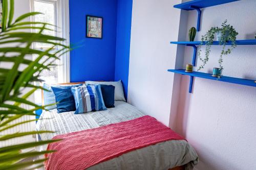 谢菲尔德6bd Home-Contractors A+ Location的一间卧室配有一张蓝色墙壁和植物床
