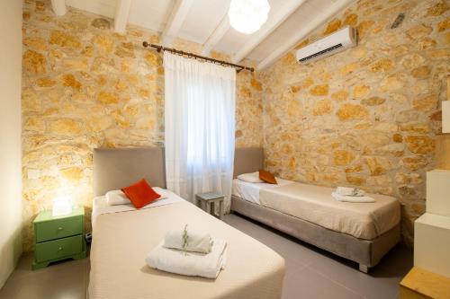 LíniaPiccolo Paradiso的一间卧室设有两张床和石墙