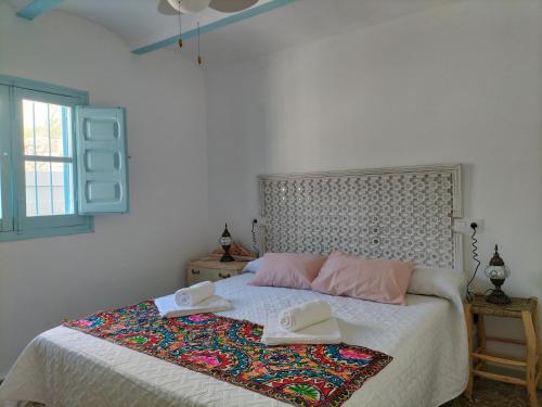 佩德罗－贝尔纳多La casa de tío Vidal的一间卧室,配有一张带两顶帽子的床