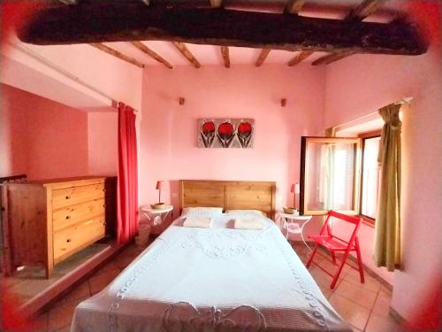 马萨The Four Angels的一间卧室配有一张大床和一张红色椅子