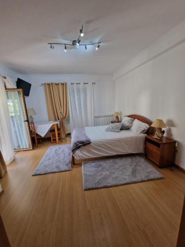 洛萨Recanto da Serra - Alojamento Local的卧室配有一张床铺,地板上铺有2个地毯。