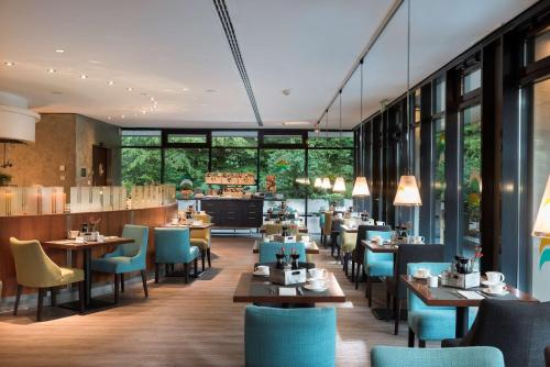 奥格斯堡道瑞特安德康格瑞萨乐奥格斯堡酒店的餐厅设有桌椅和窗户。