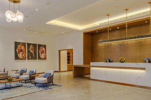 吉达Clarion Hotel Jeddah Airport的大堂设有配备椅子和柜台的等候室