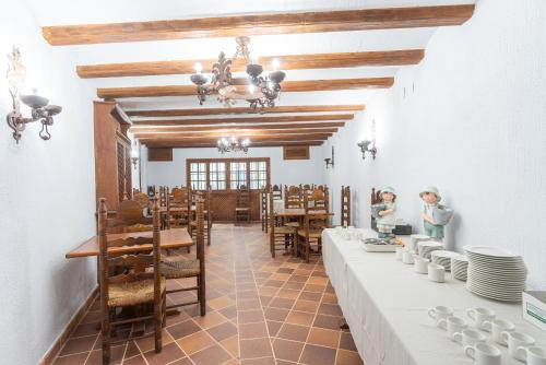 库埃利亚尔Hotel Rincón Castellano的一间设有白色桌椅的用餐室