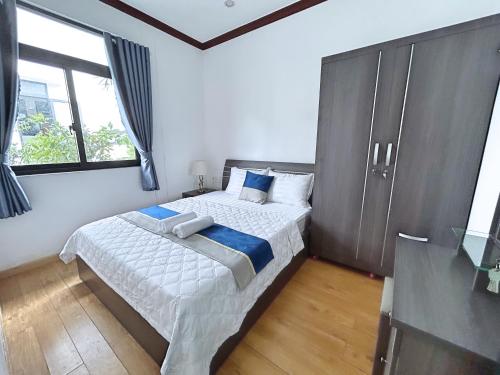 潘郎QV Luxury Apartment的一间卧室设有一张床和一个大窗户