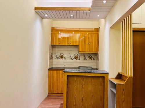 Maulvi BāzārTaj Metro的一个带木制橱柜和天花板的厨房