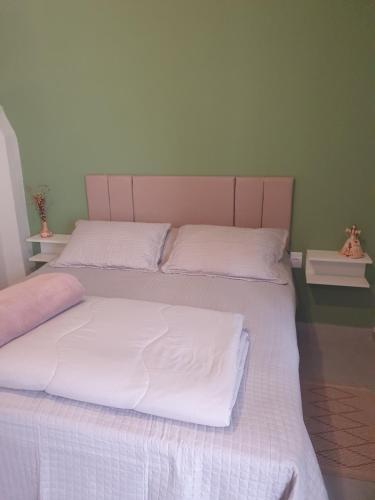 迪亚曼蒂纳Suíte privativa confortável的一间卧室配有两张带白色床单的床