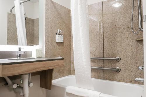 桑兹顿里士满机场烛木套房酒店的一间带水槽、浴缸和淋浴的浴室