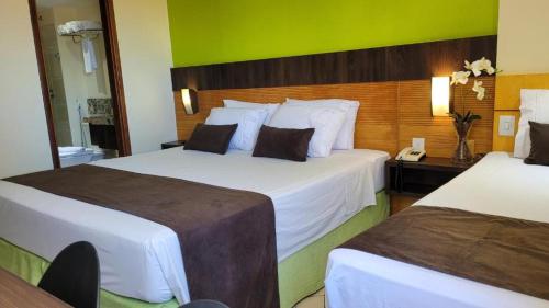 纳塔尔Plaza Suítes Natal的酒店客房带两张床和电话
