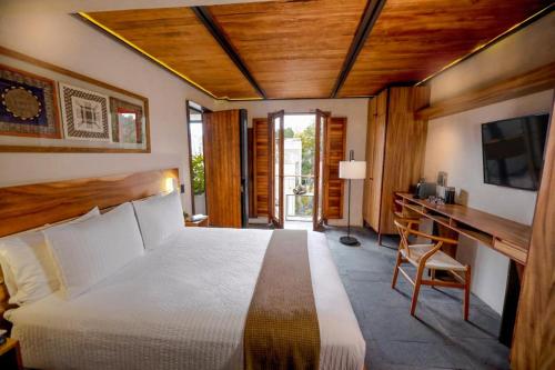 圣米格尔-德阿连德El Recinto Luxury Hotel的一间卧室配有一张床和一张书桌