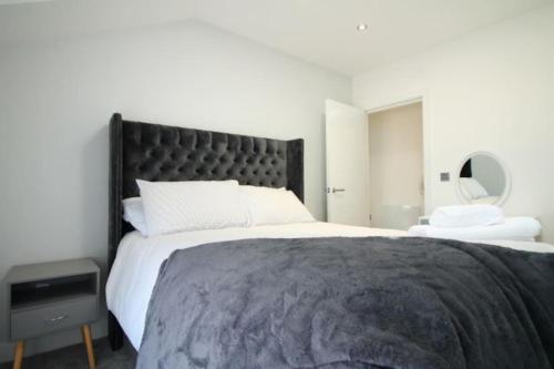 Monkwearmouth1 bedroom beachfront apartment的一间卧室配有一张大床和黑色床头板