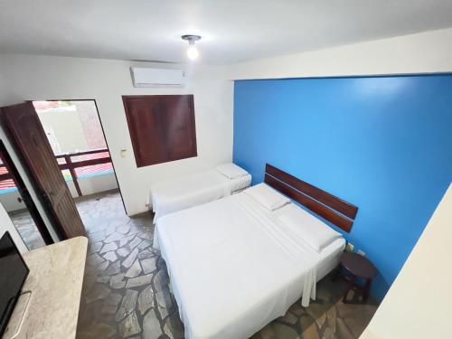 阿拉卡茹Pousada dos Caminhos的卧室配有白色的床和蓝色的墙壁