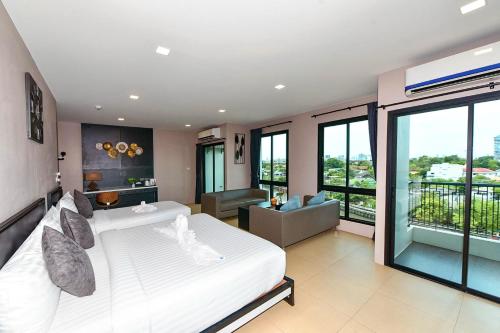 Bangkok NoiNORN Rimkhlong Bangkok นอนริมคลอง的一间带白色床的卧室和一间客厅