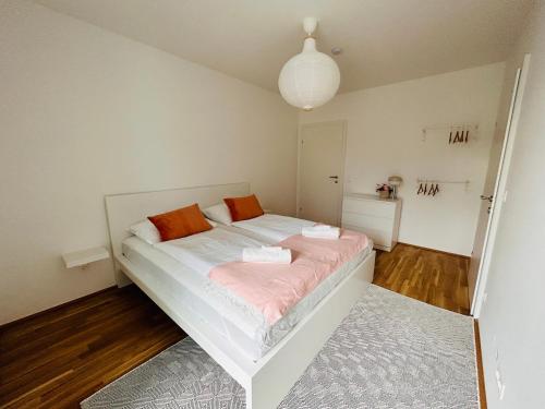 维也纳A Cozy Flat with Flair surrounded by Nature的卧室配有带橙色枕头的白色床