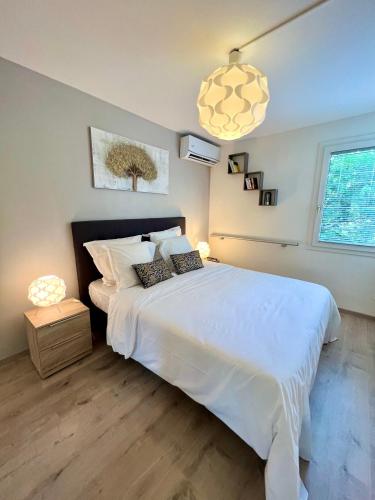 珀蒂堡Appartement Idéal的卧室配有白色大床和灯