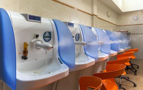 阿巴诺泰尔梅特尔姆帕特里亚酒店的浴室里一排蓝色和橙色的座位