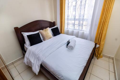 阿西里弗Greatwall的一间卧室配有一张带白色床单的床和一扇窗户。