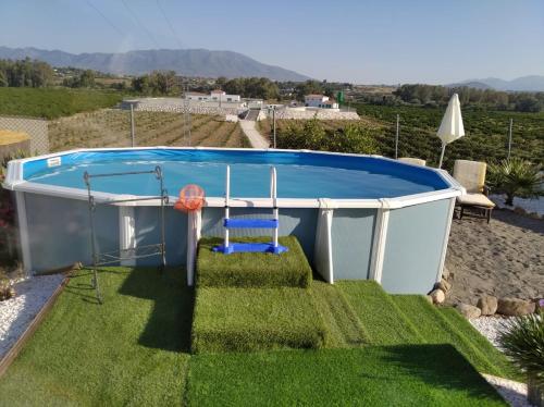 皮萨拉Home Benitez Pizarra的庭院内的小游泳池,配有椅子和秋千