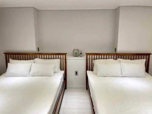 首尔Hostel Korea - Ikseon的两张睡床彼此相邻,位于一个房间里