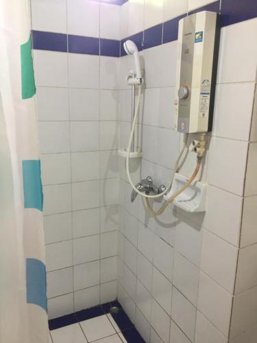 湄宏颂桑桐小屋旅馆的浴室设有白色瓷砖墙和淋浴。