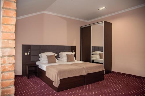 切尔诺夫策T&S Apart-Hotel的一间卧室配有一张大床和镜子
