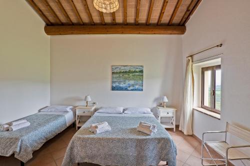 圣吉米纳诺Fattoria La Torre的一间卧室配有两张床和两张桌子