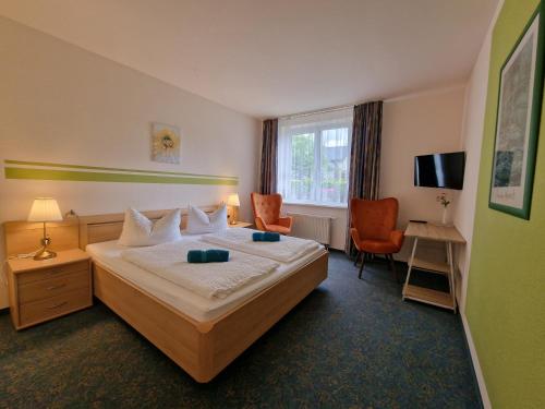 布尔格斯普瓦尔德斯罗斯酒店的配有一张床和一把椅子的酒店客房