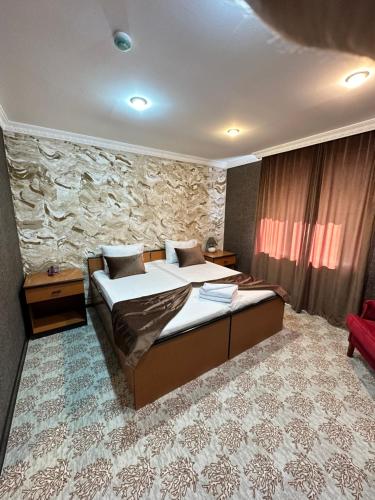 巴库RoseMary Inn的一间卧室设有两张床和石墙