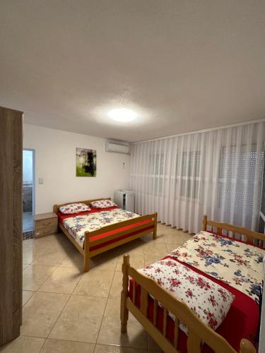 乌尔齐尼Apartments Edona的一间卧室设有两张床和窗户。