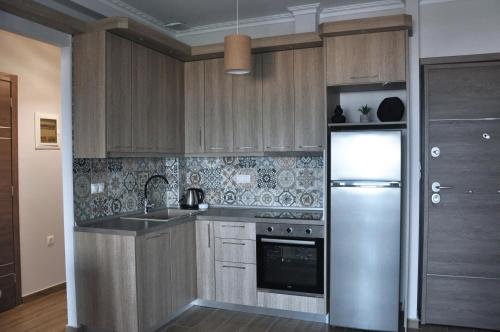 尼欧波洛伊SKYLINE Fine Living的厨房配有木制橱柜和不锈钢冰箱。