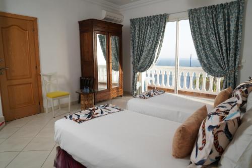 萨菲Riad Ras Lafaa的一间卧室设有两张床和大窗户