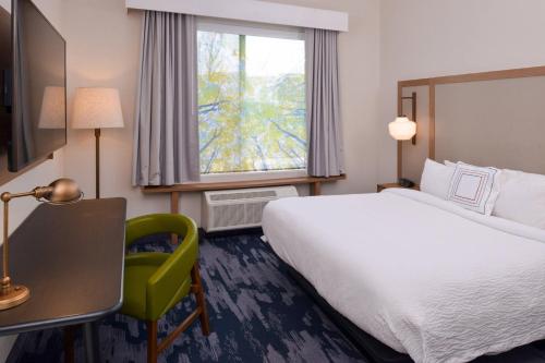 格罗夫城Fairfield Inn & Suites by Marriott Columbus Grove City的配有一张床、一张书桌和一扇窗户的酒店客房