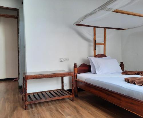 南威Kajificheni House的一间卧室设有两张床,铺有木地板