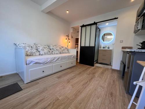 科洛米耶Studio « Le petit Prat »的卧室配有白色的床,铺有木地板